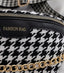 Detalle del estampado Houndstooth en blanco y negro de la riñonera